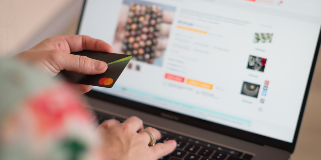 A man enters his credit card information into the computer to purchase a product online found through SEO.