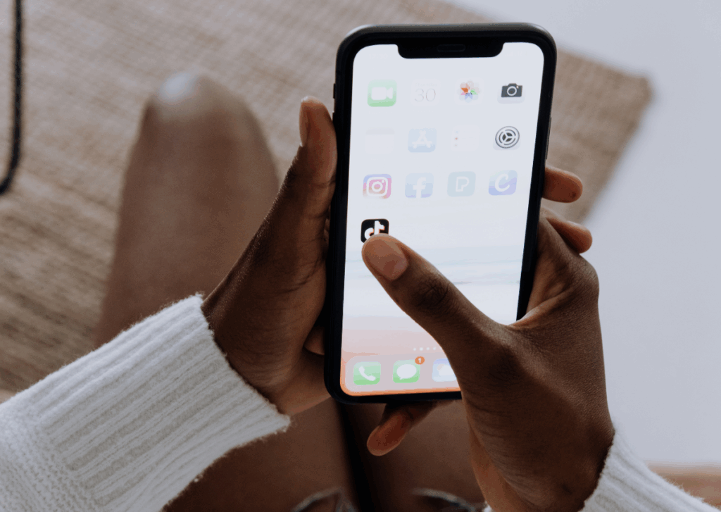 A young girl opens the TikTok app on her cellphone.